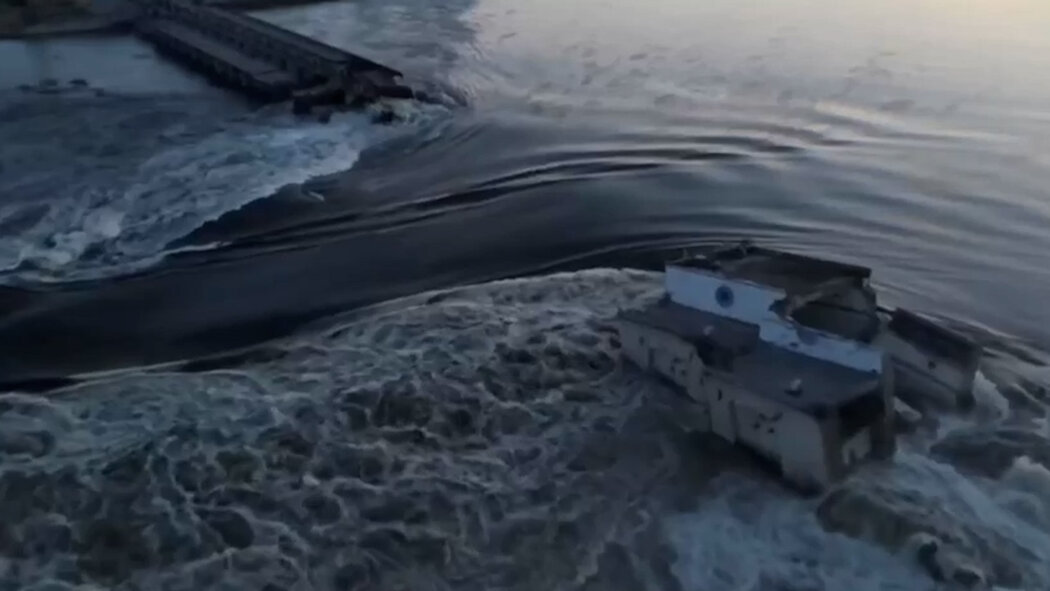 На відеовидно, що значний об’єм води вільно те че через зруйновану дамбу та електростанцію в Новій Каховці, Україна, створюючи загрозу для громад та інфраструктури вздовж водного шляху